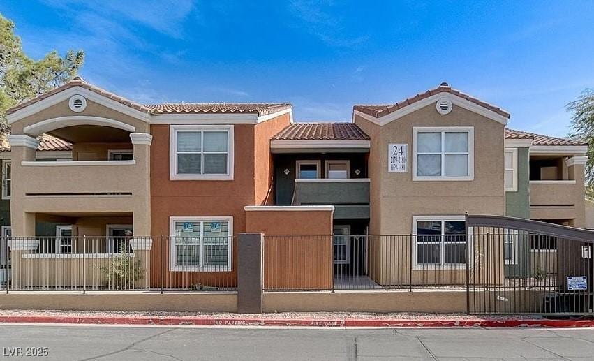 view of front of house featuring a fenced front yard, stucco siding, and a tiled roof