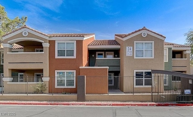 view of front of house featuring a fenced front yard, stucco siding, and a tiled roof