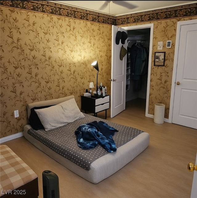 8101 W Flamingo Rd Unit 2078, Las Vegas, NV 89147 - bedroom with wallpapered walls, wood finished floors, baseboards, and a spacious closet