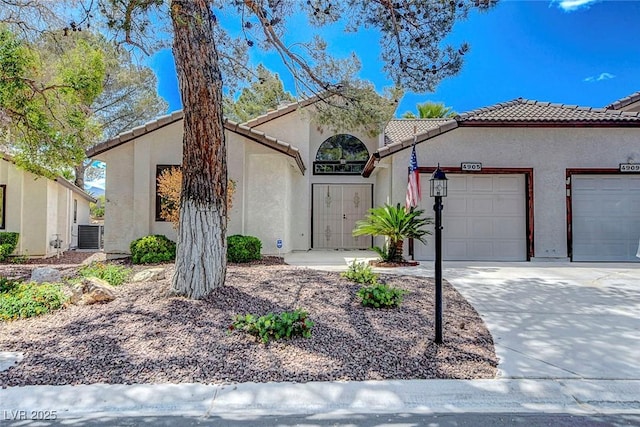 mediterranean / spanish home featuring a garage, stucco siding, concrete driveway, and a tile roof