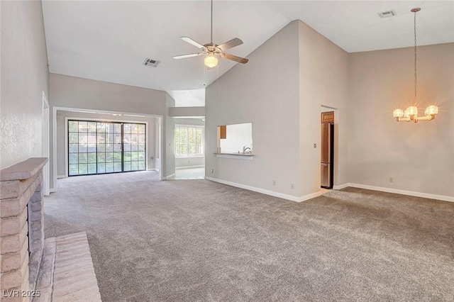 unfurnished living room featuring high vaulted ceiling, visible vents, light carpet, and ceiling fan with notable chandelier