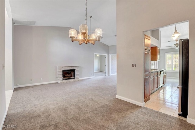 unfurnished living room with light colored carpet, a fireplace, ceiling fan with notable chandelier, baseboards, and visible vents