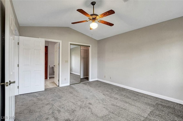 unfurnished bedroom with ceiling fan, baseboards, a closet, lofted ceiling, and carpet