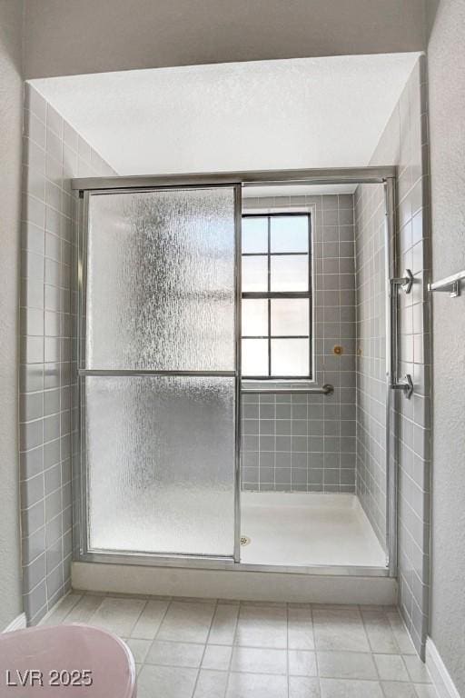 bathroom with tile patterned flooring and a stall shower