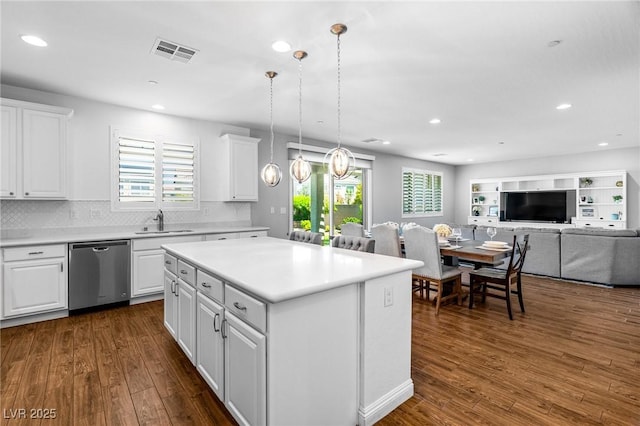 kitchen with dishwasher, a sink, recessed lighting, dark wood finished floors, and white cabinets