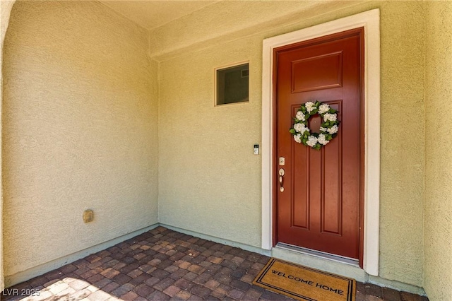 doorway to property featuring stucco siding