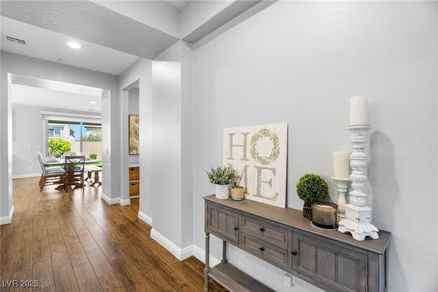 hallway featuring dark wood-style flooring, baseboards, and recessed lighting