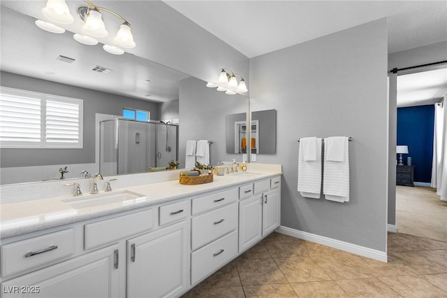 bathroom with a shower stall, double vanity, baseboards, and tile patterned floors