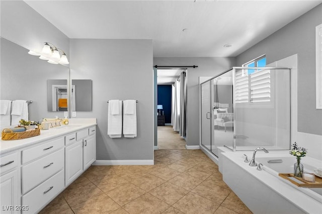 bathroom with vanity, a stall shower, tile patterned flooring, a garden tub, and baseboards