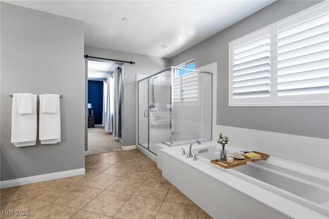 bathroom with a bath, a shower stall, tile patterned floors, and baseboards