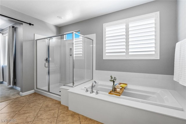 bathroom with a shower stall, a bath, tile patterned floors, and baseboards