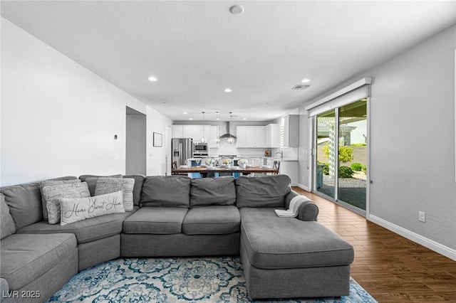 living area with recessed lighting, wood finished floors, and baseboards