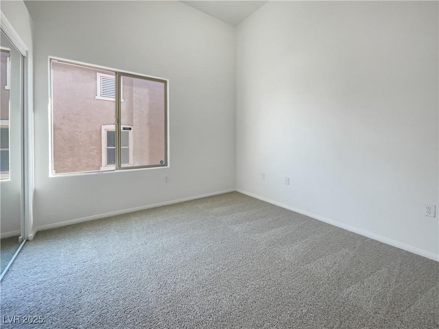 carpeted empty room featuring baseboards