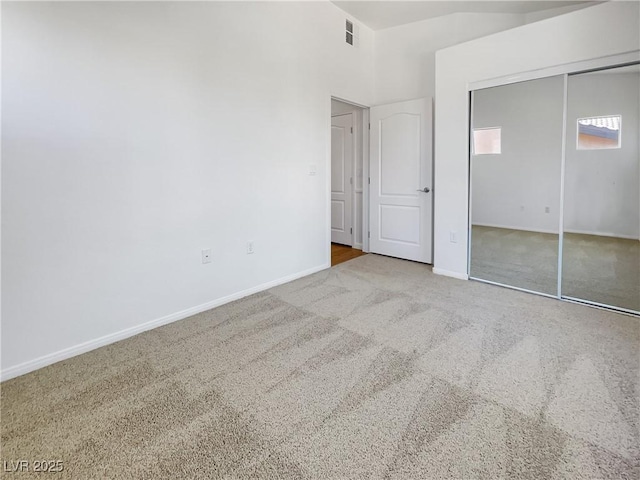 unfurnished bedroom featuring carpet flooring, baseboards, visible vents, and a closet