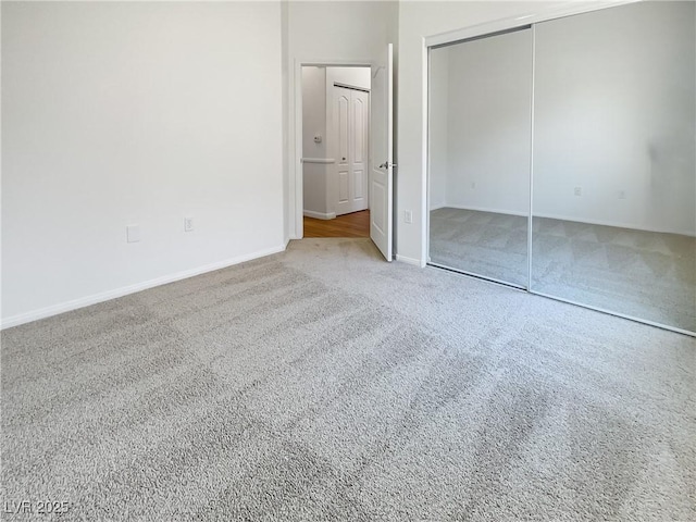 unfurnished bedroom with carpet flooring, baseboards, and a closet