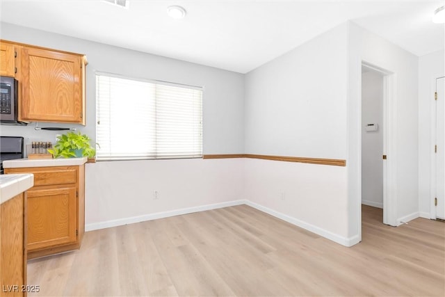9013 Meisenheimer Ave, Las Vegas, NV 89143 - kitchen with light wood finished floors, light countertops, baseboards, and stove