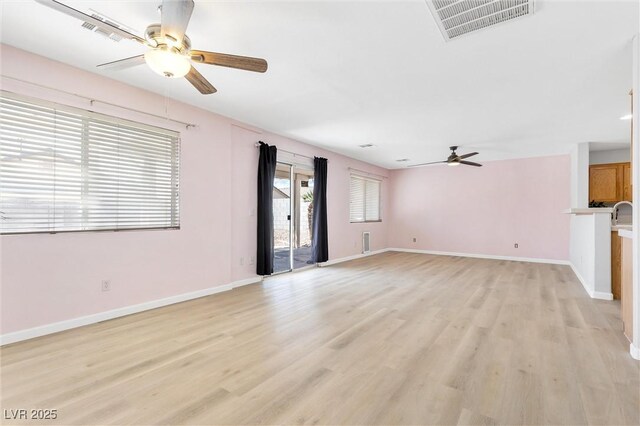 unfurnished living room with a ceiling fan, baseboards, visible vents, and light wood-style floors