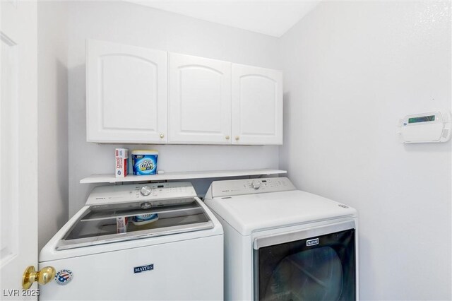 laundry area with separate washer and dryer and cabinet space
