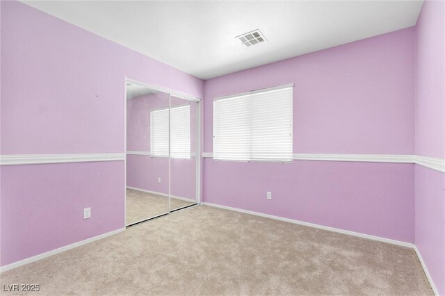unfurnished bedroom with carpet floors, baseboards, and visible vents