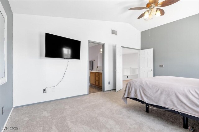 bedroom featuring ceiling fan, light colored carpet, visible vents, baseboards, and ensuite bathroom