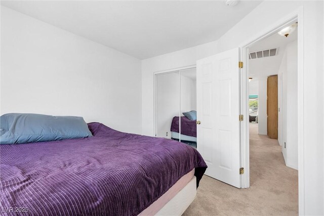 bedroom featuring light carpet, a closet, and visible vents