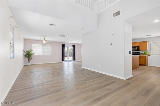 unfurnished living room with a ceiling fan, light wood-type flooring, and visible vents
