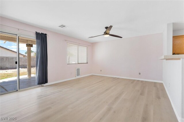 unfurnished room featuring light wood-style floors, a ceiling fan, baseboards, and visible vents