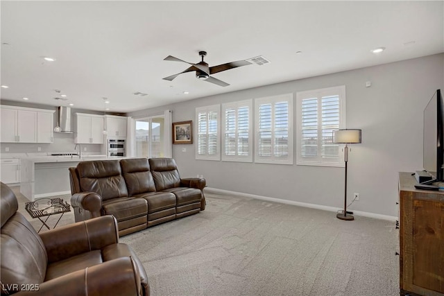 living room with ceiling fan, light carpet, recessed lighting, baseboards, and visible vents