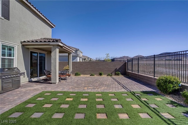 view of patio / terrace with a fenced backyard and a grill