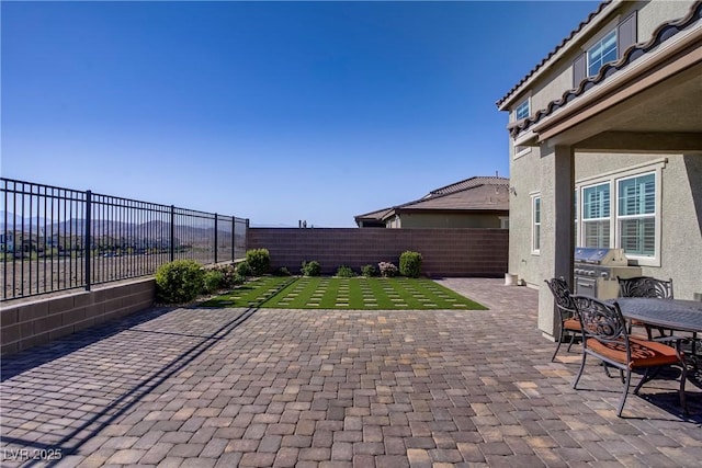 view of patio / terrace featuring a fenced backyard, area for grilling, and outdoor dining space