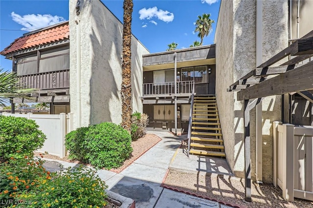 view of property with stairs and fence