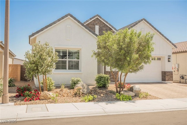 view of front of house with an attached garage, decorative driveway, board and batten siding, and stucco siding