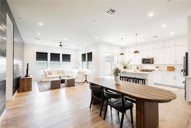 dining space featuring light wood-style floors, a ceiling fan, recessed lighting, and visible vents