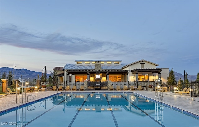 pool featuring a patio area, a mountain view, and fence