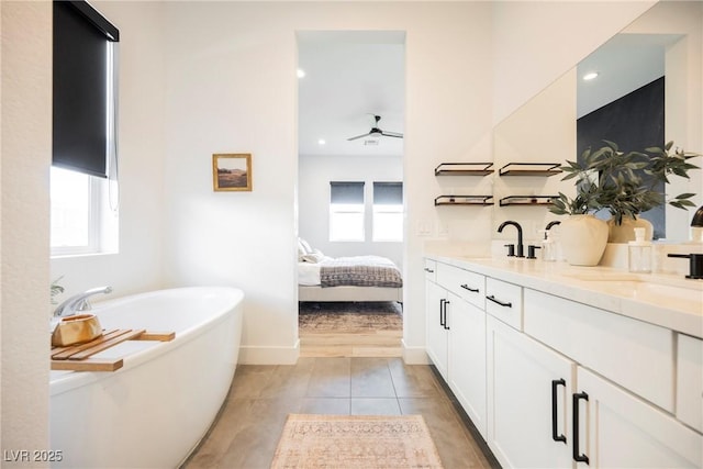 ensuite bathroom featuring double vanity, ensuite bathroom, tile patterned floors, a soaking tub, and a sink