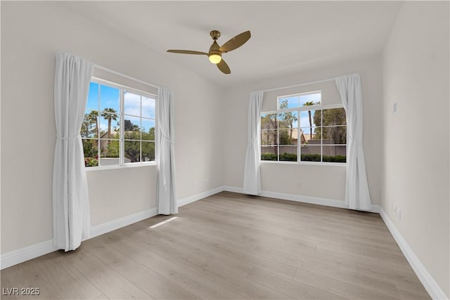 unfurnished room featuring a ceiling fan, baseboards, and light wood-style flooring