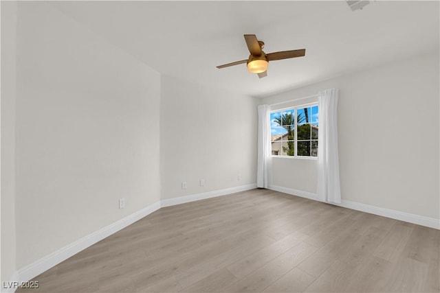 empty room with baseboards, a ceiling fan, and light wood finished floors