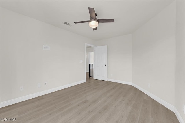 empty room featuring baseboards, ceiling fan, light wood-type flooring, and visible vents