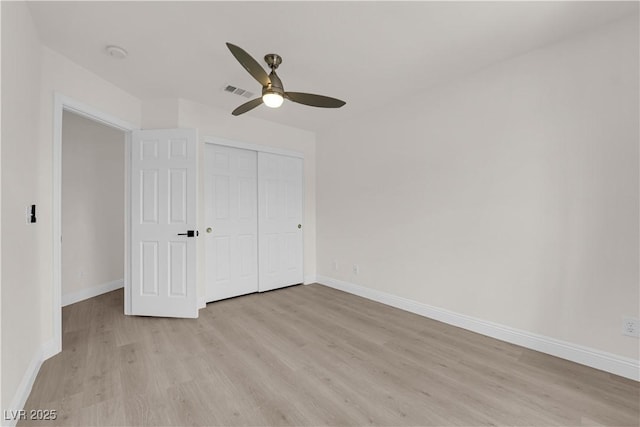 unfurnished bedroom with light wood-type flooring, baseboards, visible vents, and a closet
