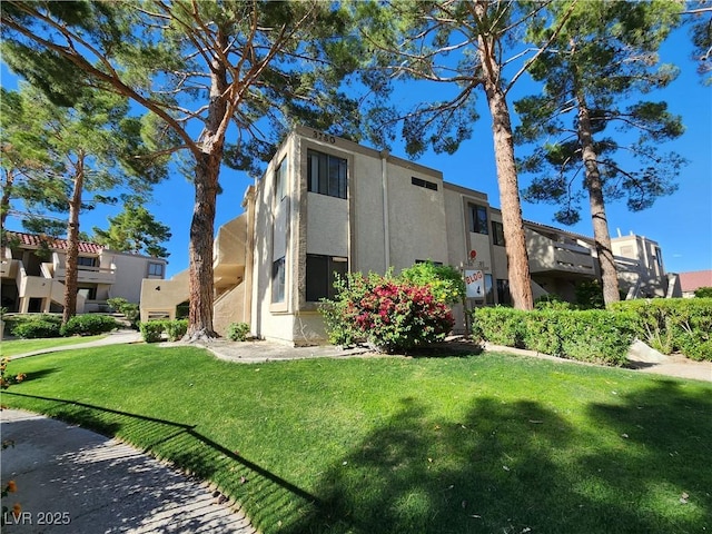 view of front of property featuring stucco siding and a front lawn