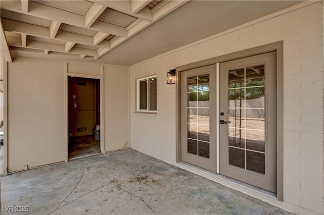 view of exterior entry with french doors and a patio area
