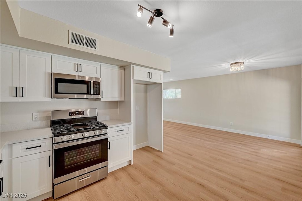 4804 Apawana Ln, Las Vegas, NV 89108 - kitchen featuring appliances with stainless steel finishes, light countertops, and white cabinets