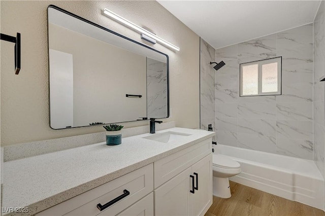 bathroom featuring toilet, vanity, shower / bathtub combination, and wood finished floors