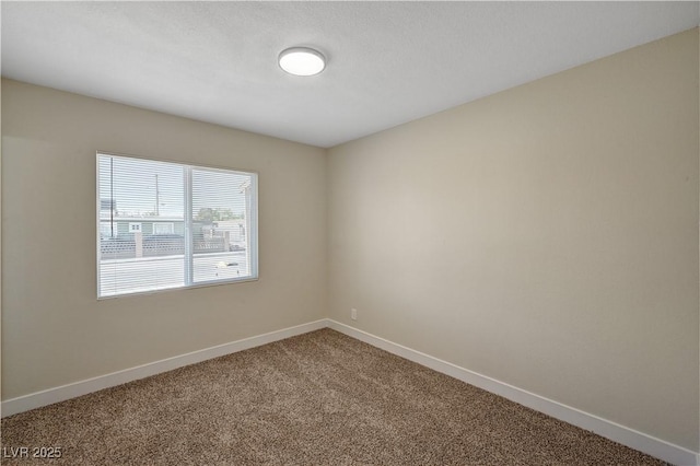 unfurnished room featuring carpet flooring and baseboards