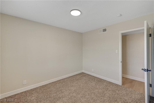 unfurnished room with light colored carpet and baseboards