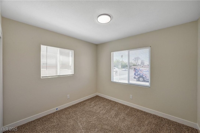 unfurnished room with carpet floors and baseboards