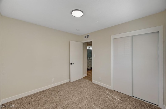 unfurnished bedroom featuring carpet, baseboards, and a closet