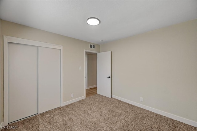 unfurnished bedroom featuring carpet flooring, baseboards, and a closet