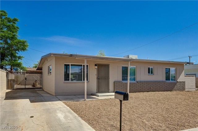 ranch-style home featuring a gate and fence