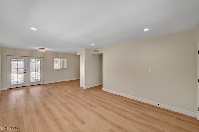 unfurnished living room with baseboards, recessed lighting, light wood-style flooring, and french doors